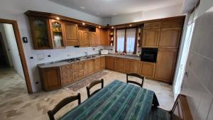 a kitchen with wooden cabinets and a table with chairs at Casa nei pini in Varazze