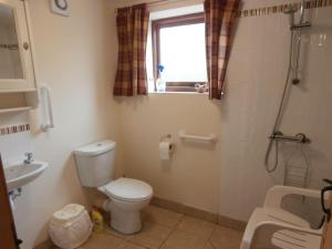 une salle de bain avec toilettes, lavabo et fenêtre dans l'établissement Clares Cosy Cottage, à Louth 9 autres photos