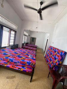 a room with four beds and a ceiling fan at Jaffna City Rest in Jaffna