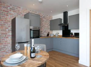 eine Küche mit einem Tisch mit Tellern und Weingläsern in der Unterkunft Adorable 1 bedroom Country Cottage in Bodewryd