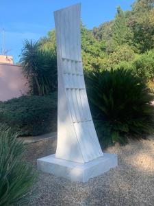 a white column in the middle of a garden at Kyriad Cannes - Mandelieu in Cannes