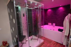 a pink bathroom with a tub and a shower at SPA privatif Love room, Le Hammam et Bulles, chez Nuits Chartraines in Chartres