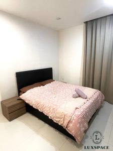 1 dormitorio con 1 cama con edredón rosa en Kuching Kozi Square Apartment 6, en Kuching