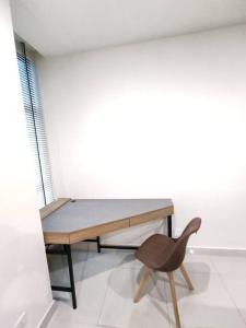 Habitación con escritorio de madera y silla. en Kuching Kozi Square Apartment 6, en Kuching 9 fotos más