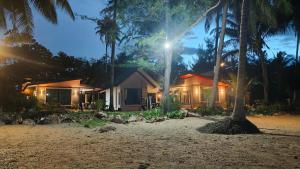 a house on the beach at night with palm trees at Baan rabianglay 1 in Ban Hin Sam Kon