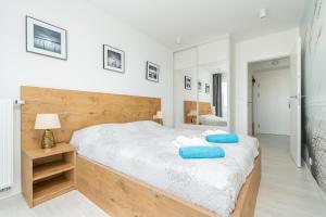 sypialnia z dużym łóżkiem i niebieskimi poduszkami w obiekcie Westin House Resort Kołobrzeg Apartament 410 w Kołobrzegu