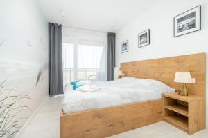 sypialnia z dużym łóżkiem z drewnianym zagłówkiem w obiekcie Westin House Resort Kołobrzeg Apartament 410 w Kołobrzegu +37 zdjęć