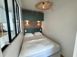 a bedroom with a bed in a room with a chandelier at Azur à la Chaume in Les Sables-dʼOlonne