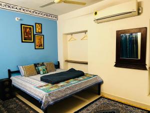 焦特布尔Aura B&B - The Haveli Homestay的蓝色墙壁间的一张床位