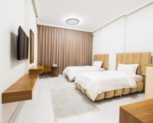 a hotel room with two beds and a flat screen tv at Liza Hotel in Muscat +15 photos