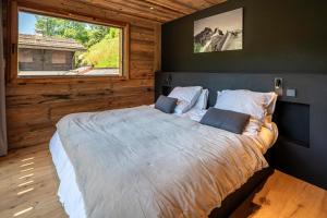 a bedroom with a large bed with a window at Chalet TheMoon - La Clusaz in La Clusaz