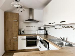 a white kitchen with a sink and a stove at Obermerkenbergerhof in Hofstetten
