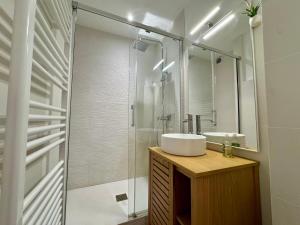 a bathroom with a sink and a glass shower at Azur à la Chaume in Les Sables-dʼOlonne