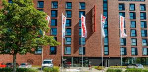 un edificio de ladrillo rojo con banderas delante en havenhostel Cuxhaven, en Cuxhaven