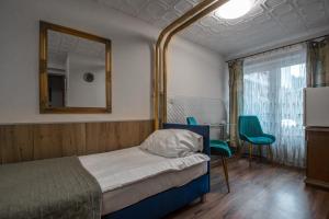 a bedroom with a bed and a mirror and a table at Villa Asesor in Gdańsk