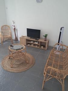 a living room with two chairs and a television at Jems Appartment Villa in Mare Sèche +18 photos