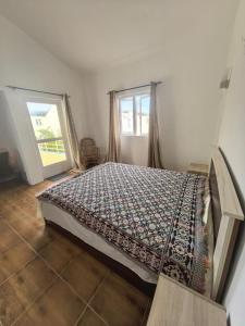 a bedroom with a bed with a comforter and a window at Jems Appartment Villa in Mare Sèche +18 photos