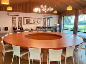 uma grande sala de jantar com uma grande mesa de madeira e cadeiras em The Louts Villa em Chung-lan