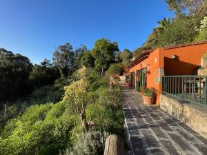 a walkway next to an orange building at Finca El Lance Zumacal in Firgas