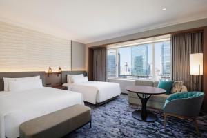a hotel room with two beds and a table at The Westin Osaka in Osaka