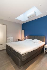 a bedroom with a large bed with a blue wall at Relaxed Apartments Haarlem in Haarlem