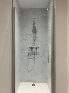 a bathroom with a shower with white marble walls at Vakantiewoning Laurijn in Bilzen +13 photos