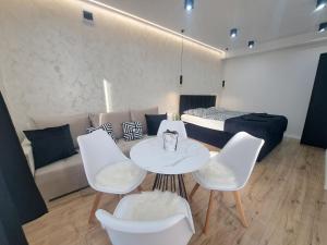 a room with a table and chairs and a bed at Belvárosi Lux Apartman 2 in Vásárosnamény