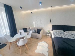 a room with a bed and a table and a couch at Belvárosi Lux Apartman 2 in Vásárosnamény