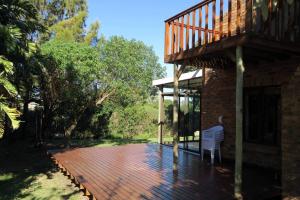 una terraza con una silla en la parte superior de una casa en Hidden gem in bush 350m from main beach, en Bettyʼs Bay
