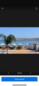 a television screen with a picture of a beach with umbrellas at Suite Aurora in Crotone