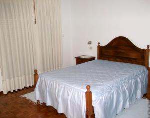 ein Schlafzimmer mit einem Bett mit einer weißen Tagesdecke in der Unterkunft O Pimpao in Geres