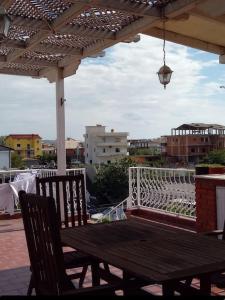 una mesa de madera y sillas bajo una pérgola en Villa Mondi, en Durrës 50 fotos más