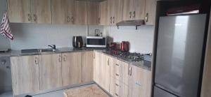 a kitchen with wooden cabinets and a stainless steel refrigerator at 35 Amanda - Durbanville in Cape Town