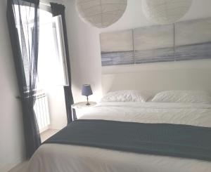 a bedroom with a white bed and a window at Secret Garden Apartment Center Opatija with private parking space in Opatija