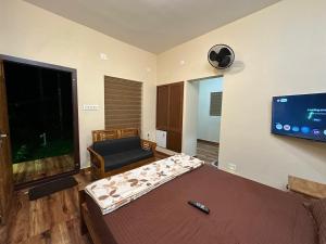 a bedroom with a bed and a flat screen tv at Jungle Getaway Wayand in Pulpally