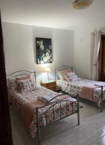 a bedroom with two beds and a table with a lamp at Casa Terria in Tías