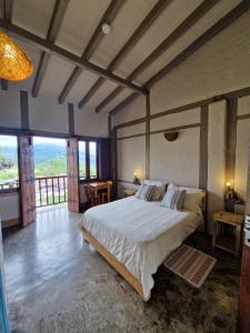 a bedroom with a large bed and a large window at Coffee Tree Boutique Hostel in Salento +153 photos