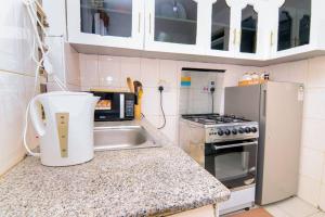 a small kitchen with a sink and a refrigerator at Enkaji Homestay 1 Bedroom Apartment Naivasha in Naivasha