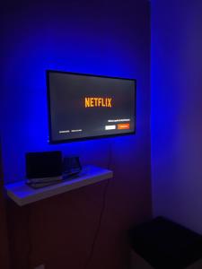 un televisor con el logo de Netflix en una pared azul en Bali, en Saint-Martin-Lalande