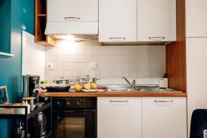 a kitchen with white cabinets and a sink at Wagnerstays Royal Billiard Residence in Prague
