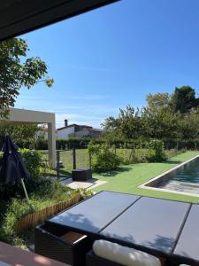 Un patio con una mesa y una piscina. en Bali, en Saint-Martin-Lalande