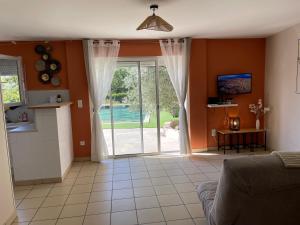 una sala de estar con una gran puerta corredera de cristal en Bali, en Saint-Martin-Lalande