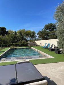 una piscina con un portátil en un patio en Bali, en Saint-Martin-Lalande