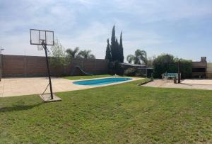 a basketball hoop in a yard with a basketball court at Casa con piscina para 8 personas in Mercedes