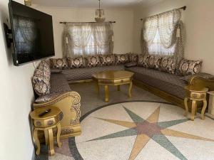 a living room with a couch and a tv at Villa appartement jardin et piscine in Meknès