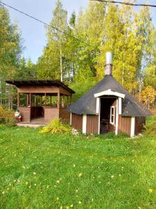 un vecchio edificio con un portico e un gazebo di Villa Maarianvaara a Rikkaranta