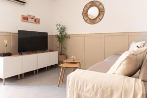 ein Wohnzimmer mit Fernseher und Sofa in der Unterkunft Appart proche plage, idéal et tranquille, parking privé - arrivée autonome - lit queen size in La Seyne-sur-Mer