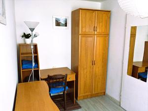 a room with a desk and a table and a cabinet at Słoneczny Pokój w bloku na 1 p dla 1 Niepalącej Osoby od 1 do 12 miesięcy in Kraków