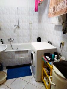 a bathroom with a washing machine in front of a bath tub at Słoneczny Pokój w bloku na 1 p dla 1 Niepalącej Osoby od 1 do 12 miesięcy in Kraków