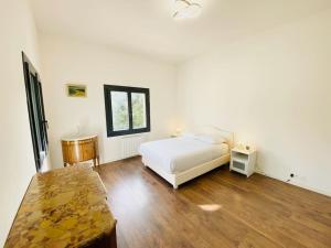 a bedroom with a white bed and a wooden floor at La Villa Lou Castel in Sanary-sur-Mer +32 photos